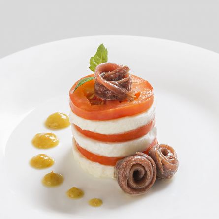 Millefoglie di caprese con acciughe del Cantabrico su salsa di pomodoro giallo al basilico